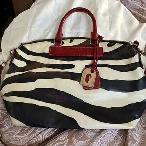 Dooney & Bourke Zebra design with red trim and interior.